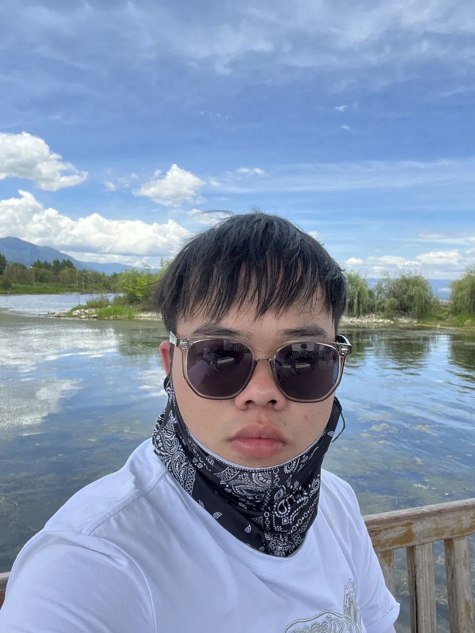 Jinhao in sunglasses and a bandana by the lake