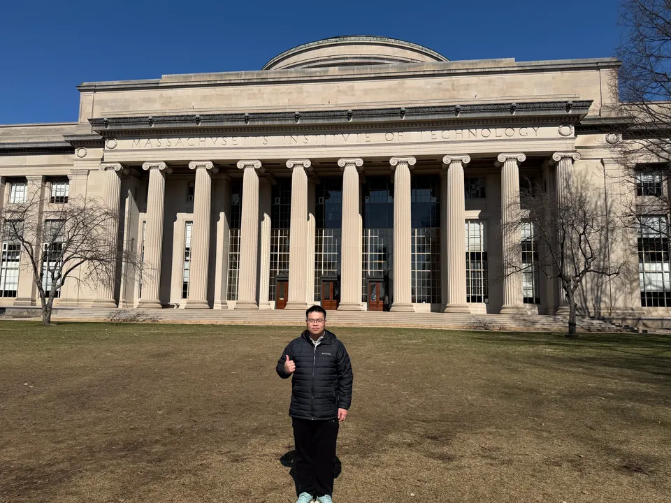 Jinhao on a lawn in front of a domed building with tall columns